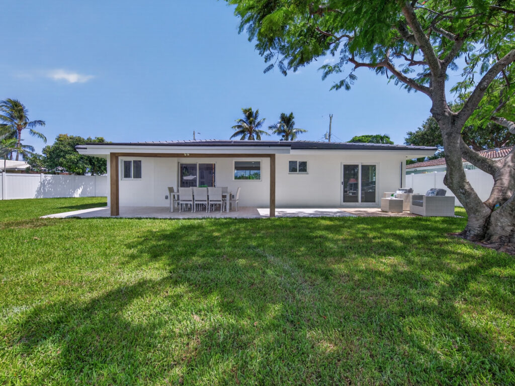 Rear yard with the shade tree and covered patio seen from the lawn