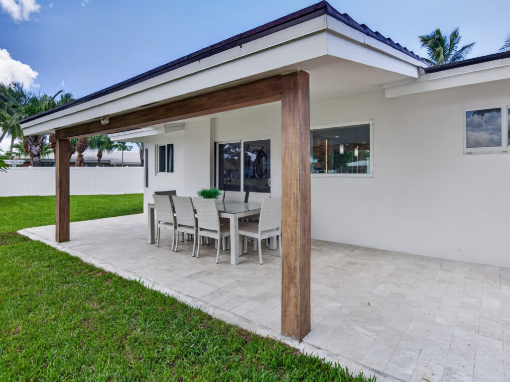 Covered travertine patio set with an outdoor dining table