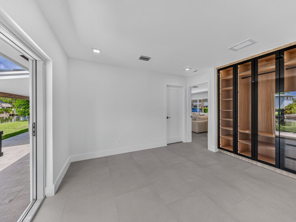 Primary bedroom with sliding doors open to the rear yard and canal